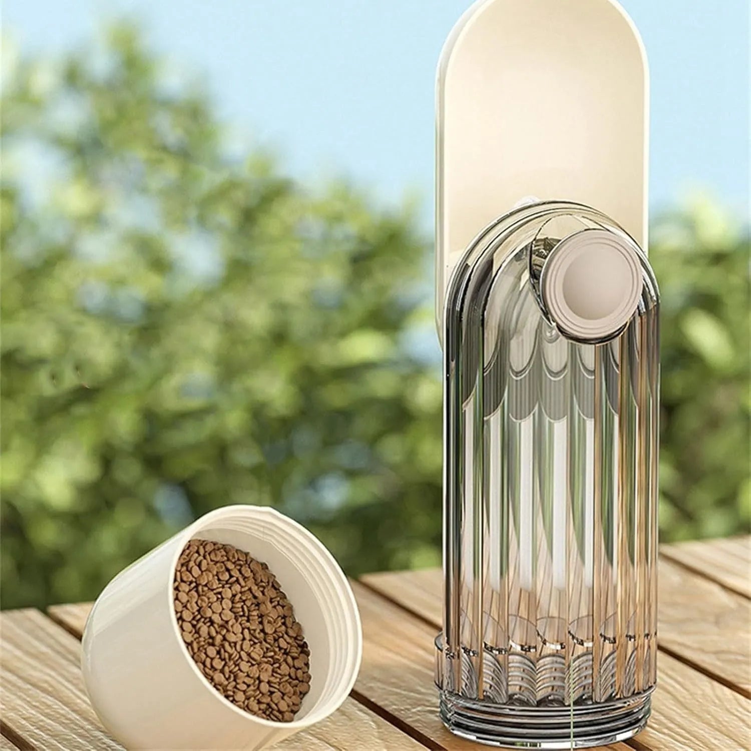 Foldable beige dog water bottle with food dispenser tray extended for drinking outdoors