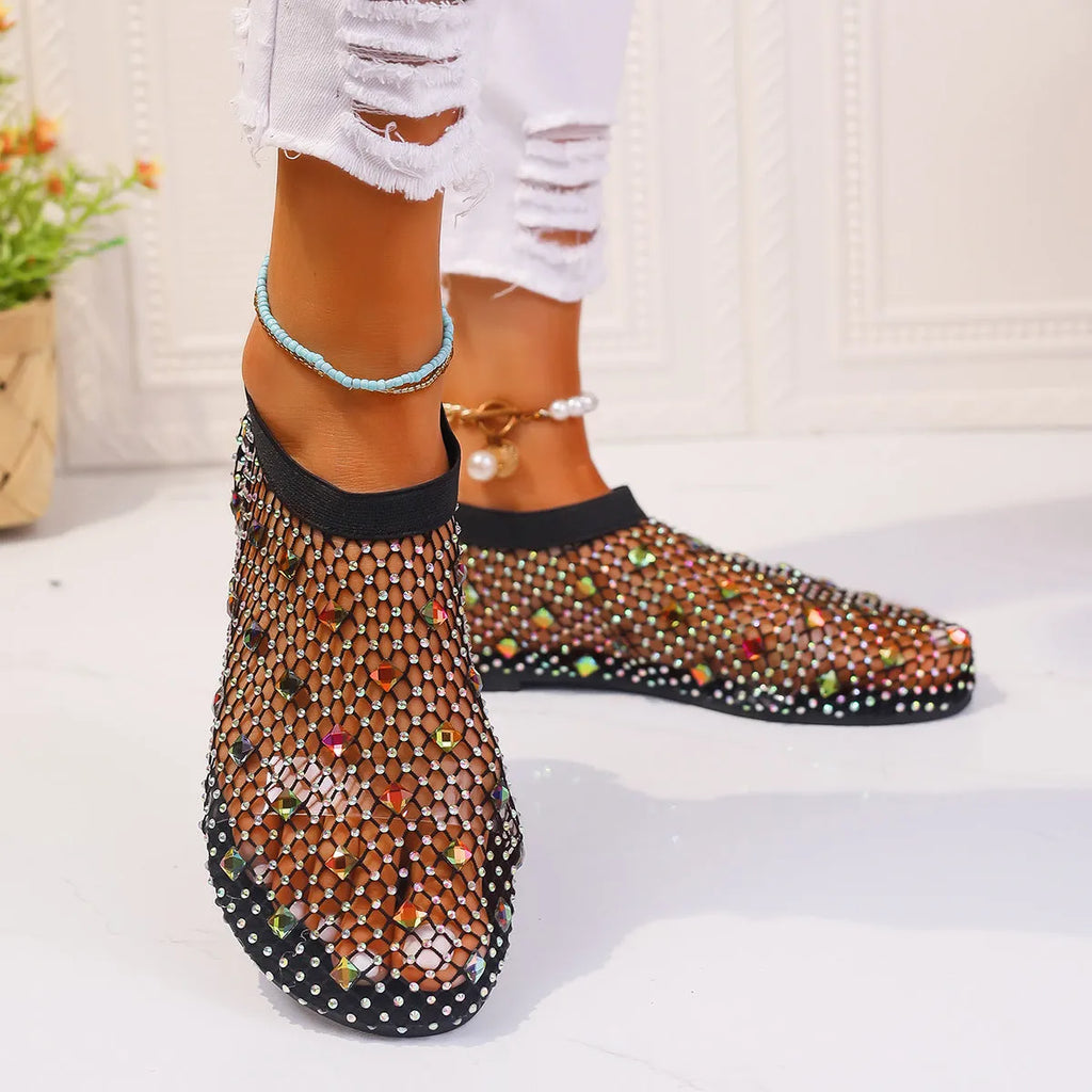 Women's flat sandals with colourful rhinestones on a mesh upper and a rubber sole.