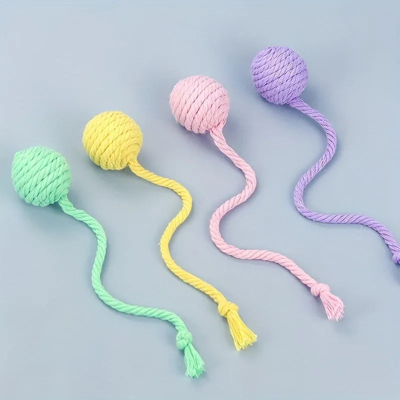 Green and pink plastic cat toy balls with ropes and internal bells.