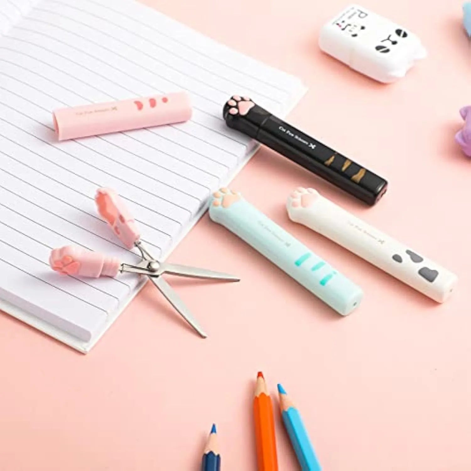 Set of four small folding scissors with cat paw handles in black, blue, pink, and white colours.