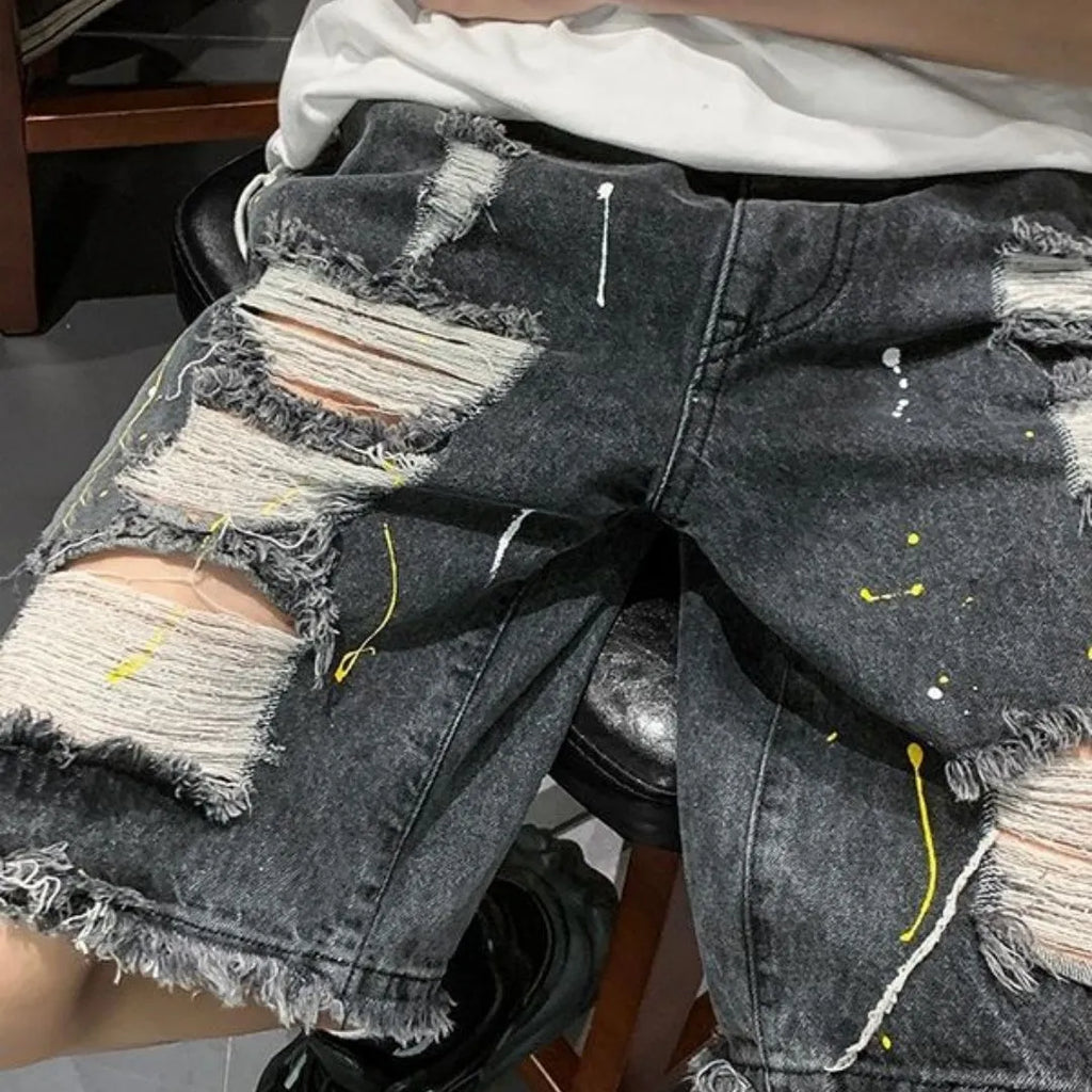 Men's loose fit water washed light blue denim shorts with hole details on a mannequin.