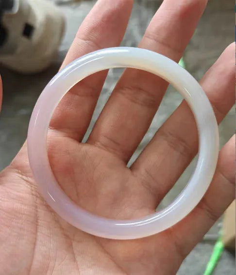 A natural agate wide tyre bracelet showing one of six colour options, such as pink or blue agate, on a wrist.