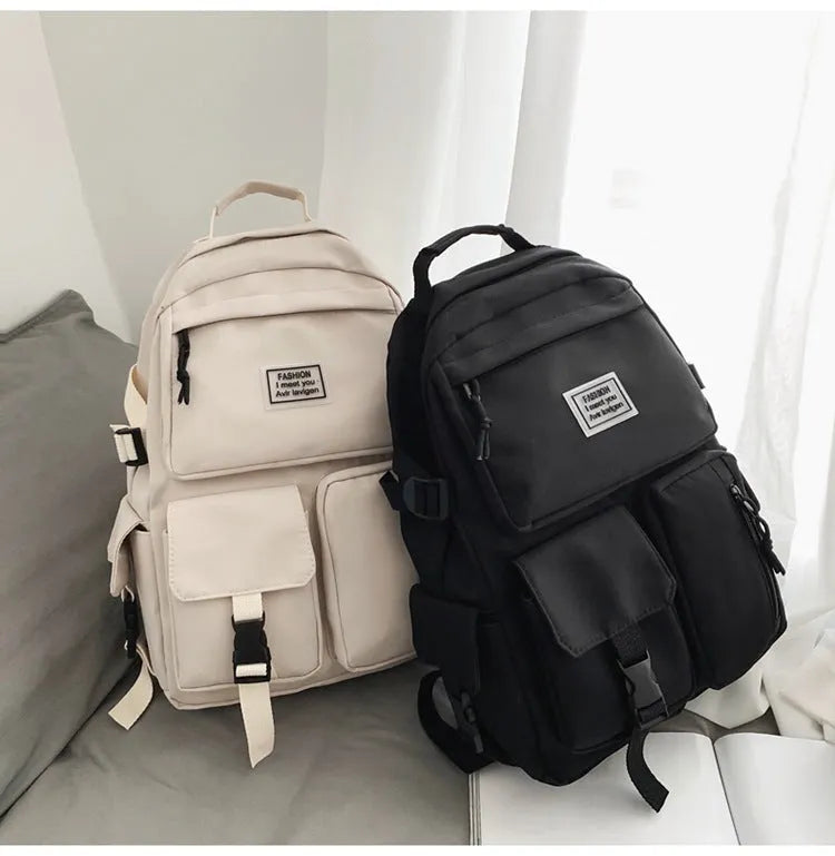 Black and white soft nylon student backpack showing external pockets and internal laptop compartment.