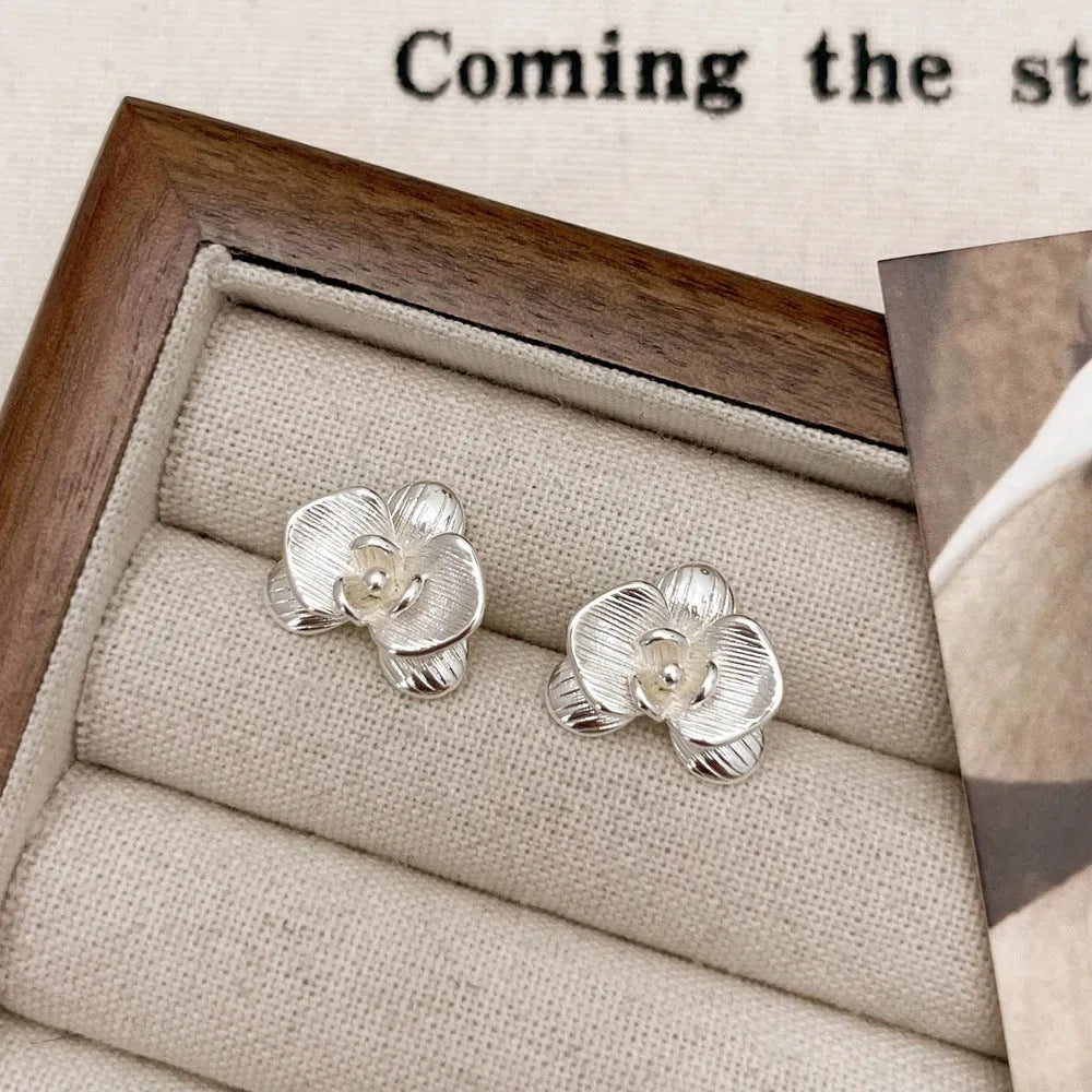 A pair of women's retro-style flower drop earrings with petal details in a gold or silver electroplated finish.