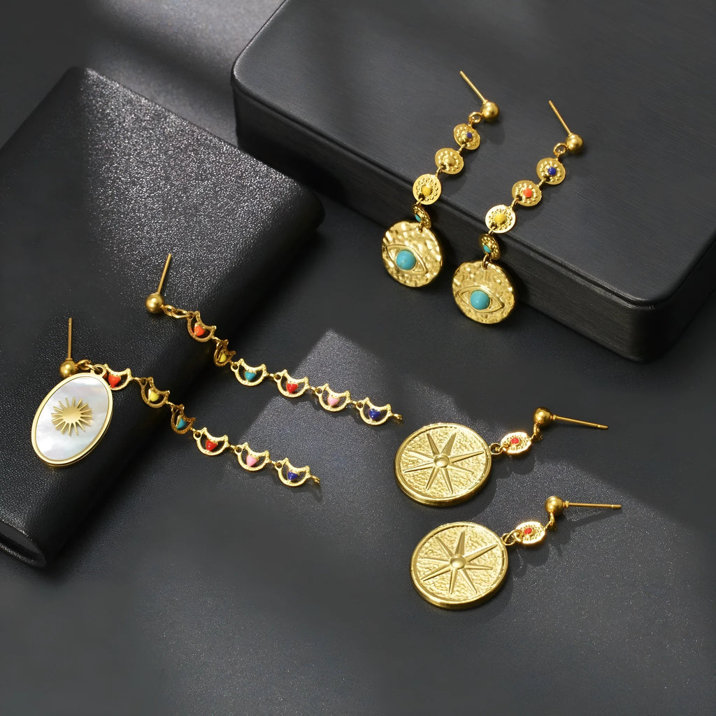 Stainless steel geometric drop earrings showing Eight Awn Star, Eye, and Shell Sun design options.