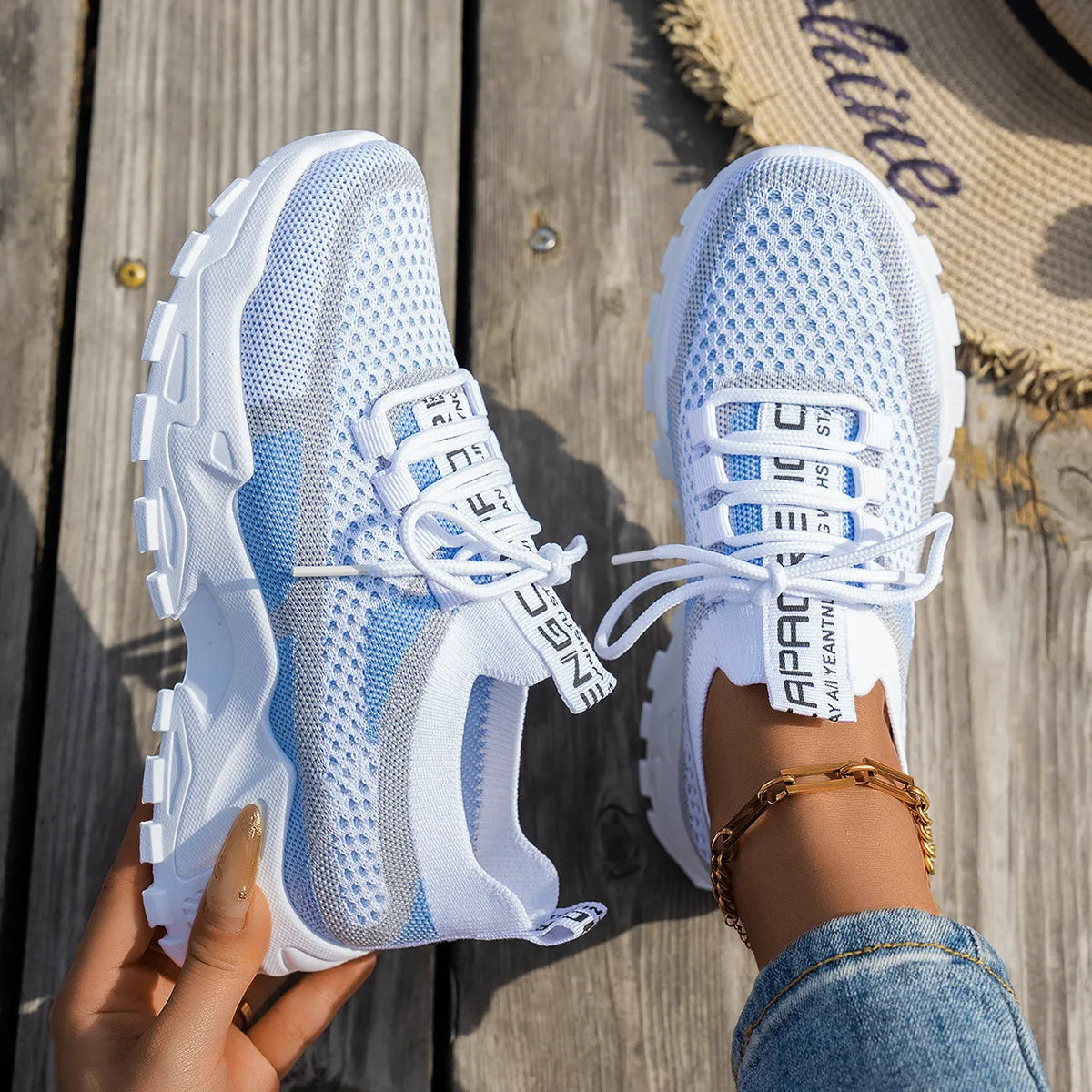 Women's Flyknit mesh lace-up sneakers in a grey colourway showing round toe and low profile.