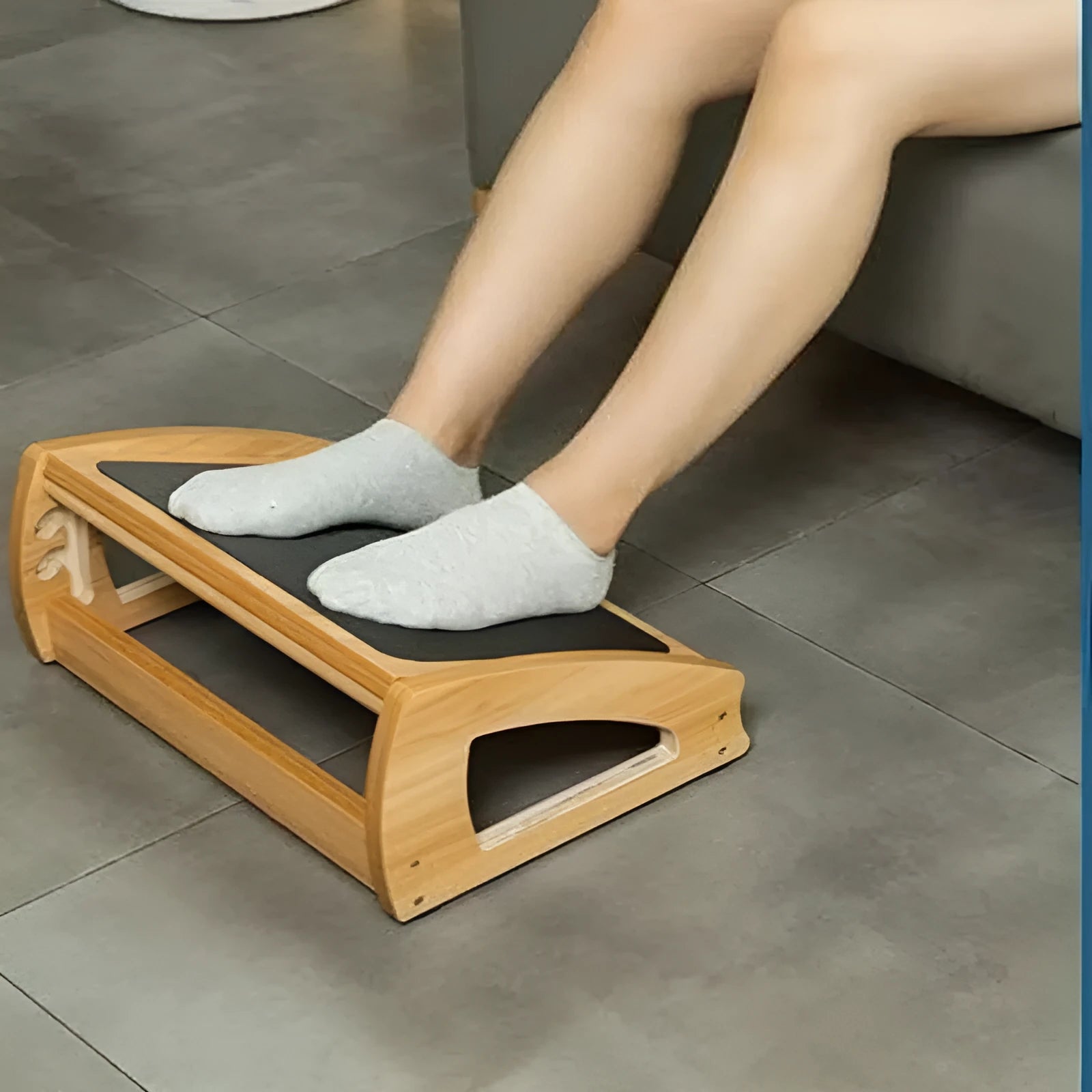Adjustable bamboo office desk footstool in natural wood colour on a floor.