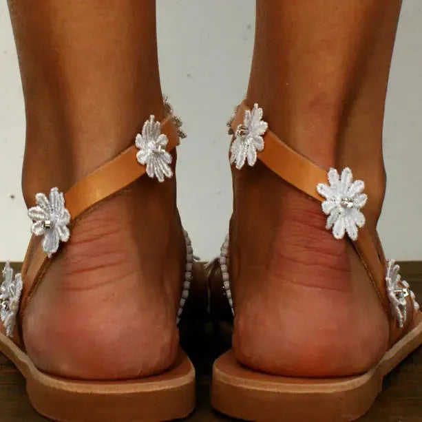 Brown flat beach sandals with herringbone toe design and floral pattern on the artificial PU upper.