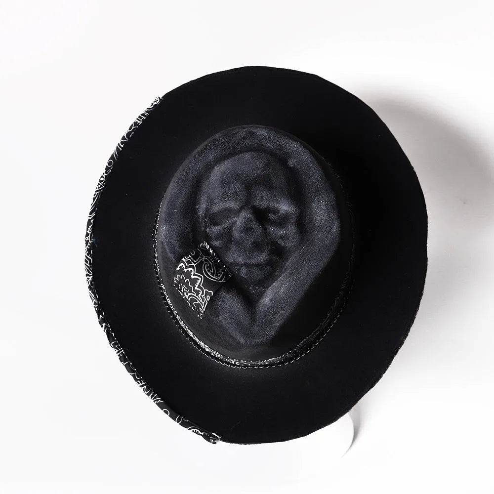 Handmade wool felt skull hat with a pointed conical crown on a neutral background