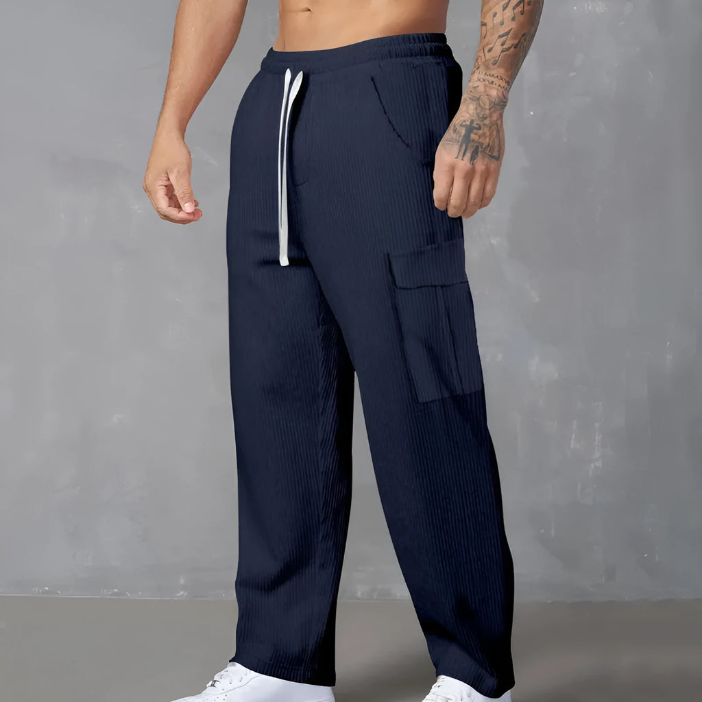 Men's navy blue corduroy cargo trousers with wide-leg design and drawstring waist laid flat.