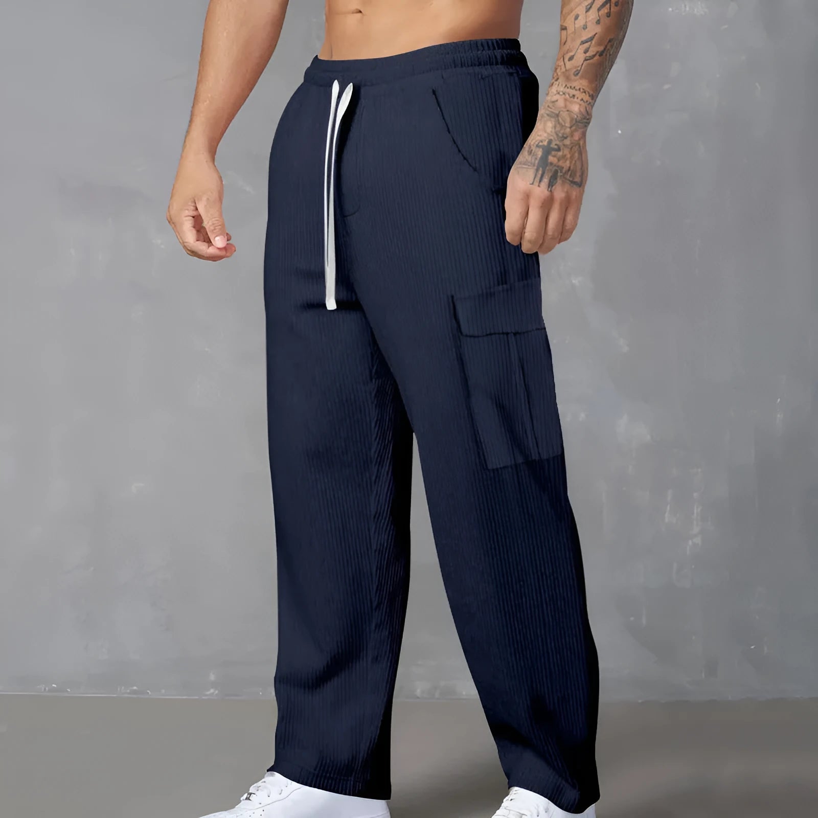 Men's navy blue corduroy cargo trousers with wide-leg design and drawstring waist laid flat.