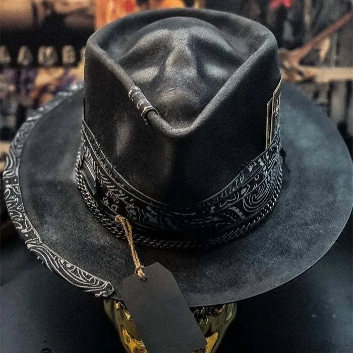Handmade wool felt skull hat with a pointed conical crown on a neutral background