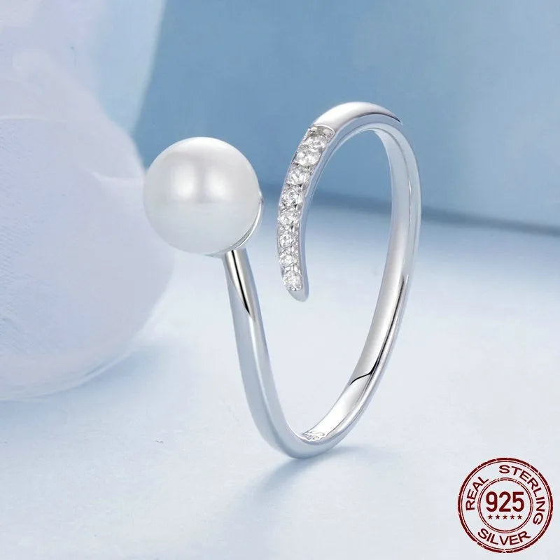 Adjustable sterling silver ring with natural shell pearls on open loop design