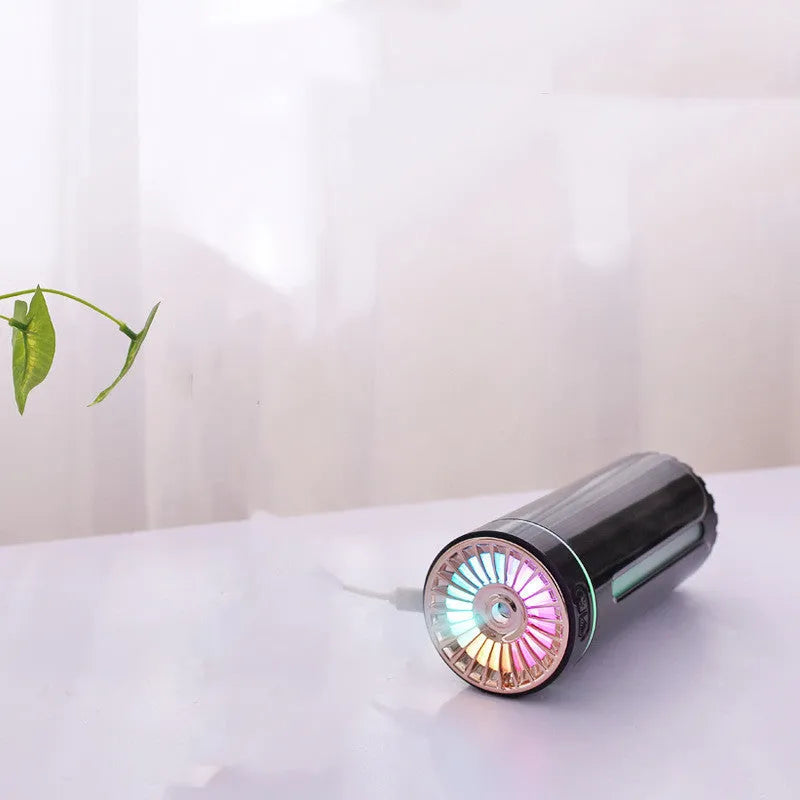 Compact black wireless humidifier with colourful LED lights sitting in car cup holder