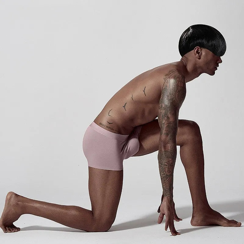 Men's seamless one-piece modal underwear in green, shown flat, highlighting its mid-waist and solid colour design.