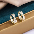 A pair of geometric-shaped copper earrings with a zircon-treated 14K yellow finish.