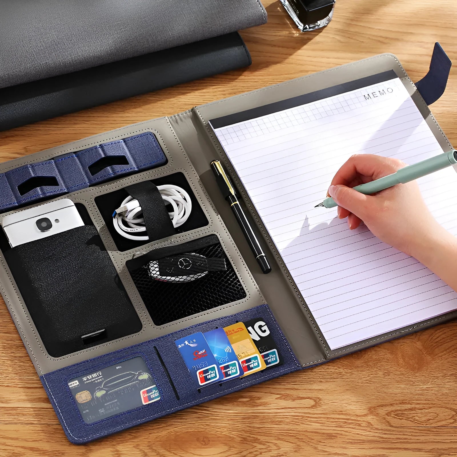 Black leather A4 business folder with notepad and pen on a desk