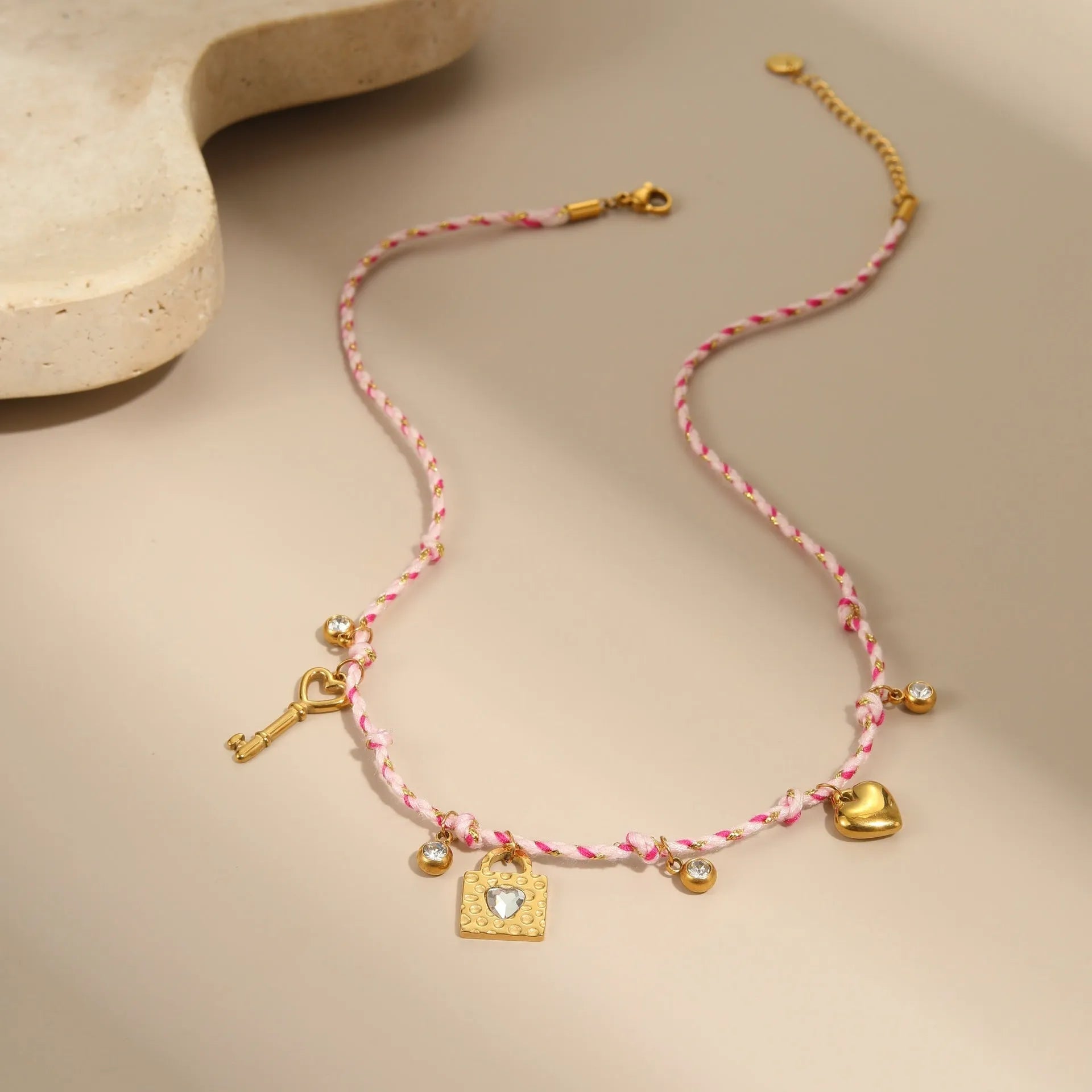 Handmade colour braided rope and stainless steel necklace with heart-shaped pendant on adjustable chain.