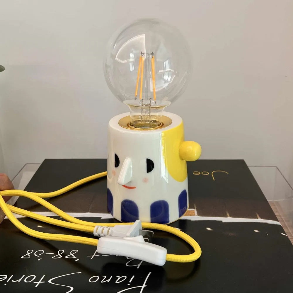 Handmade ceramic table lamp with ball headlight shade on wooden surface