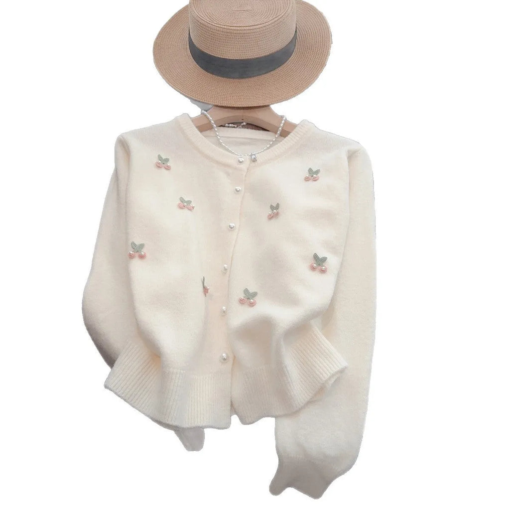 A pink cashmere blend women's cardigan sweater coat with beaded detailing and a round neck, shown open.