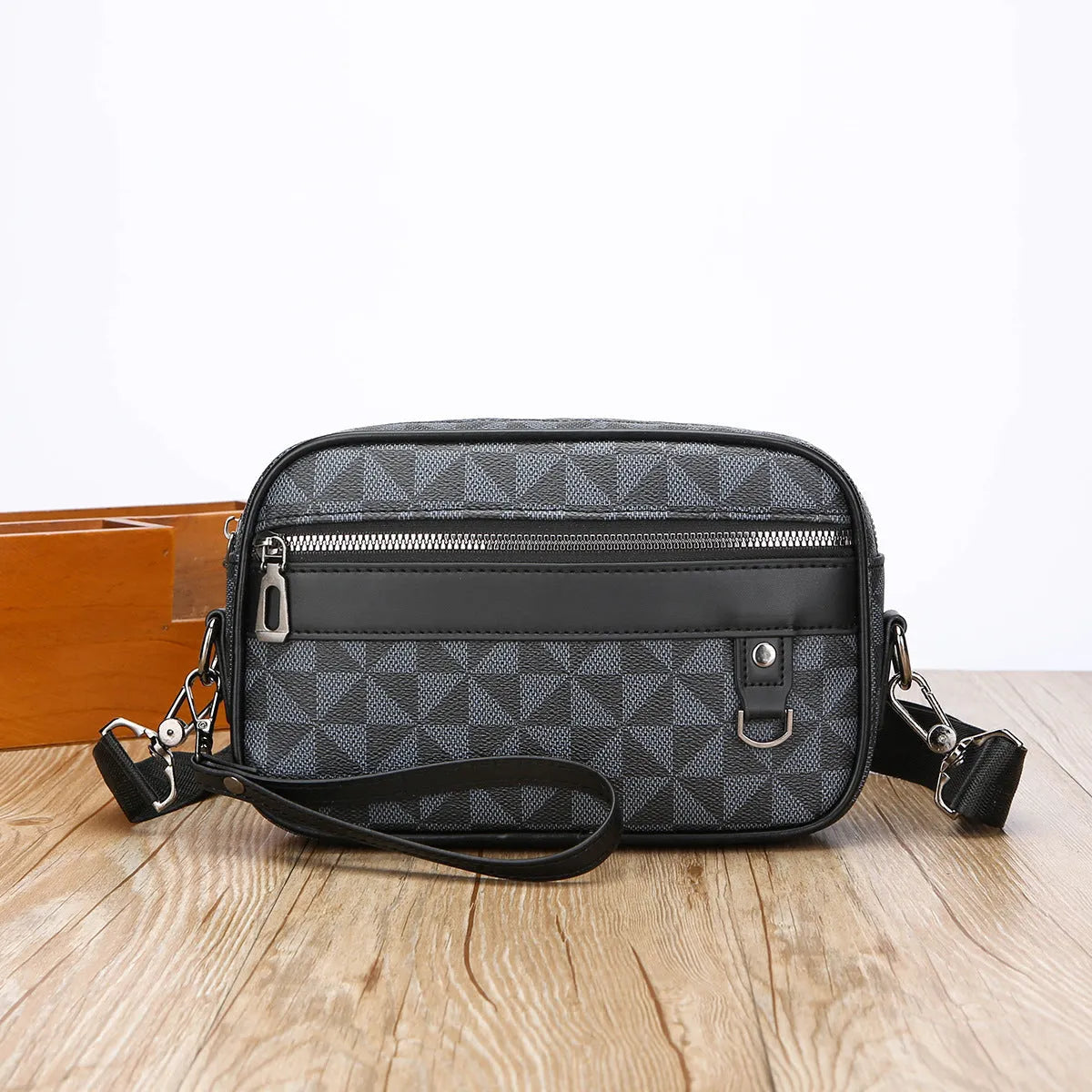 Men's black casual shoulder messenger bag with geometric pattern, shown with handheld top handle and adjustable shoulder strap.