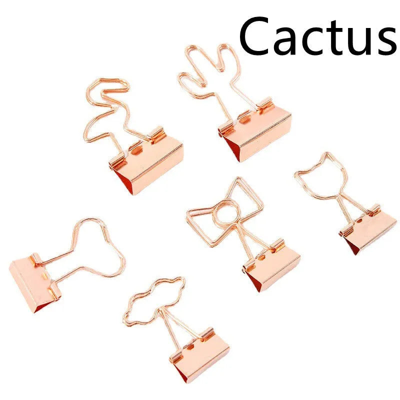Small gold-plated decorative metal clip with long-tail design, showing optional flamingo, love, clouds, cat, cactus, and bow motifs.