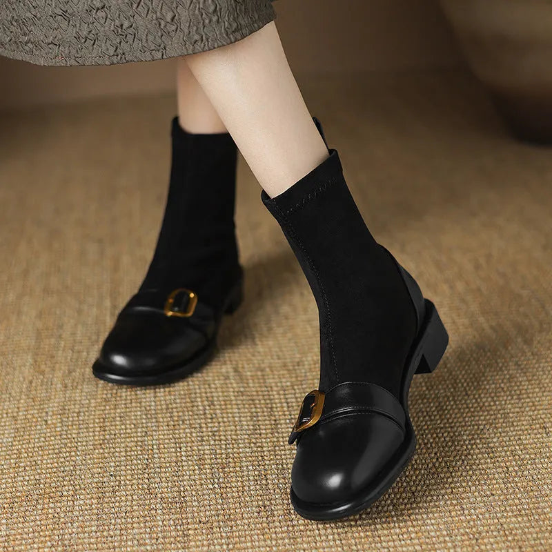 Women's black low-heel Martin boots with lace-up front and decorative belt buckle stitching.