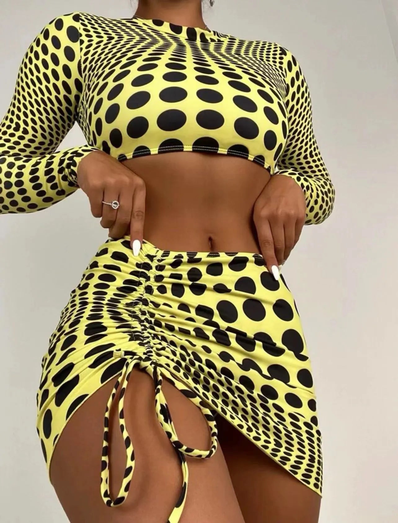 Green polka dot women's three-piece swimsuit set showing bikini top, skirt, and bra.