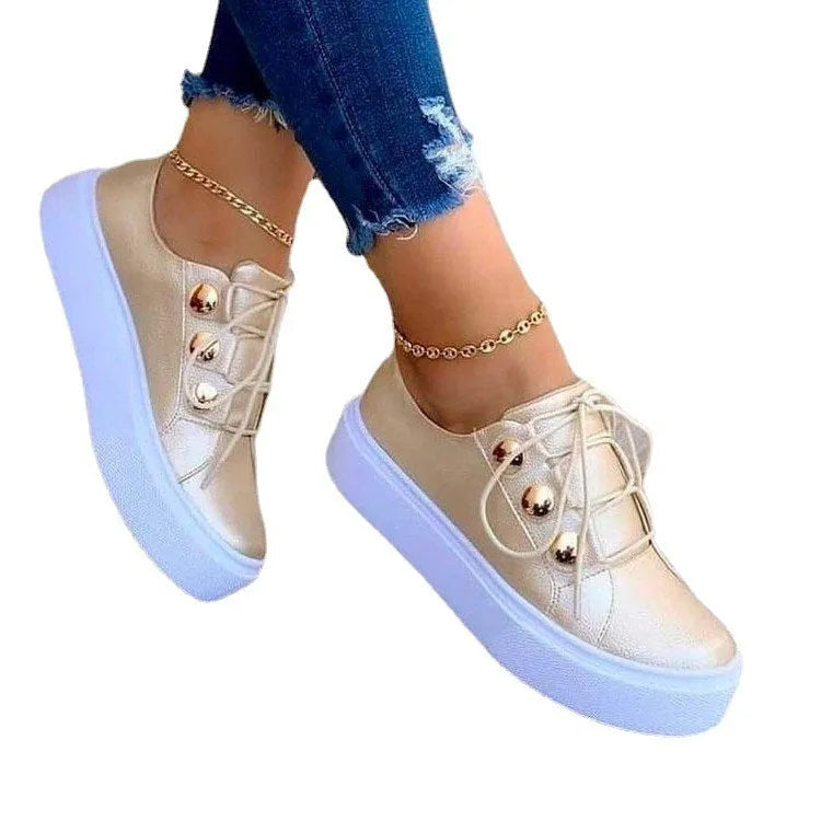 Women's white lace-up flats sneakers with round toe and silver rivet details on the side.