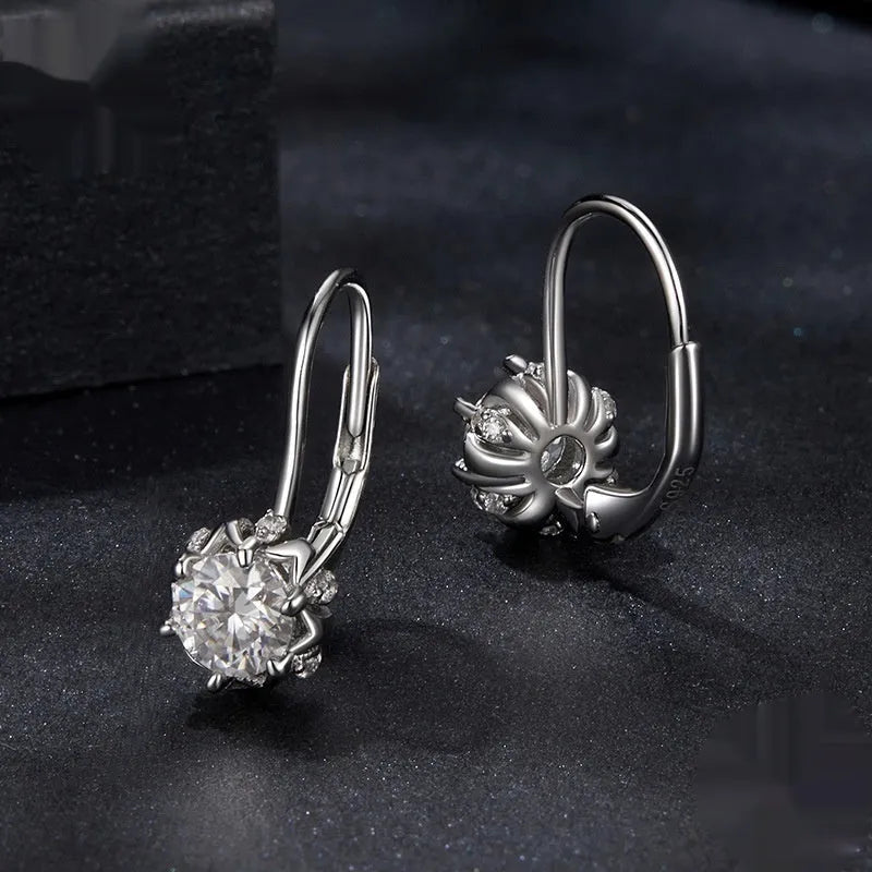 Close-up of a sterling silver flower bud ear clip with a white gold plated finish and a central 0.5 carat moissanite stone.