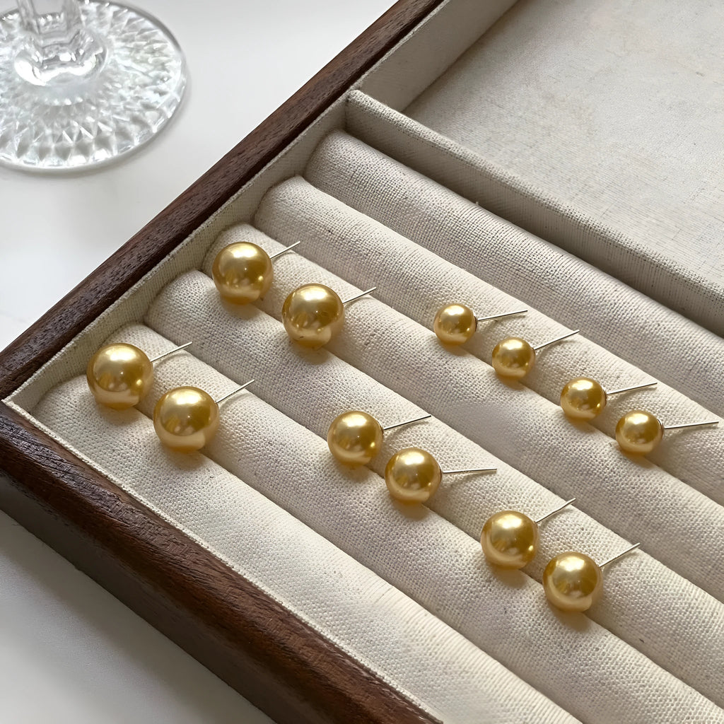 Geometric pearl stud earrings with Awn star motifs in silver, showing size options