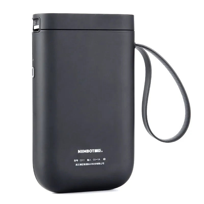 D11 Bluetooth label printer in black colour on a desk next to a smartphone showing the label design app.