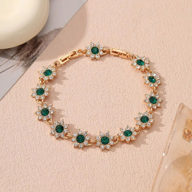 Electroplated zinc alloy bracelet with flower-shaped coloured gems in gold or silver tone.