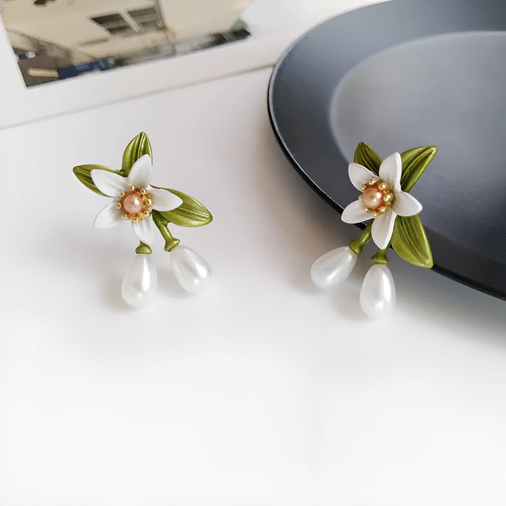 A pair of women's alloy flower-shaped clip-on earrings with contrasting sterling silver needle floral details.