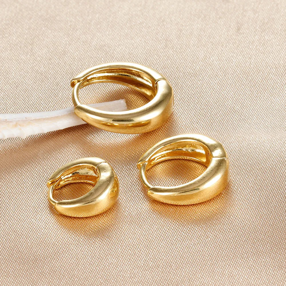 Three glossy geometric copper earrings set in gold electroplated finish