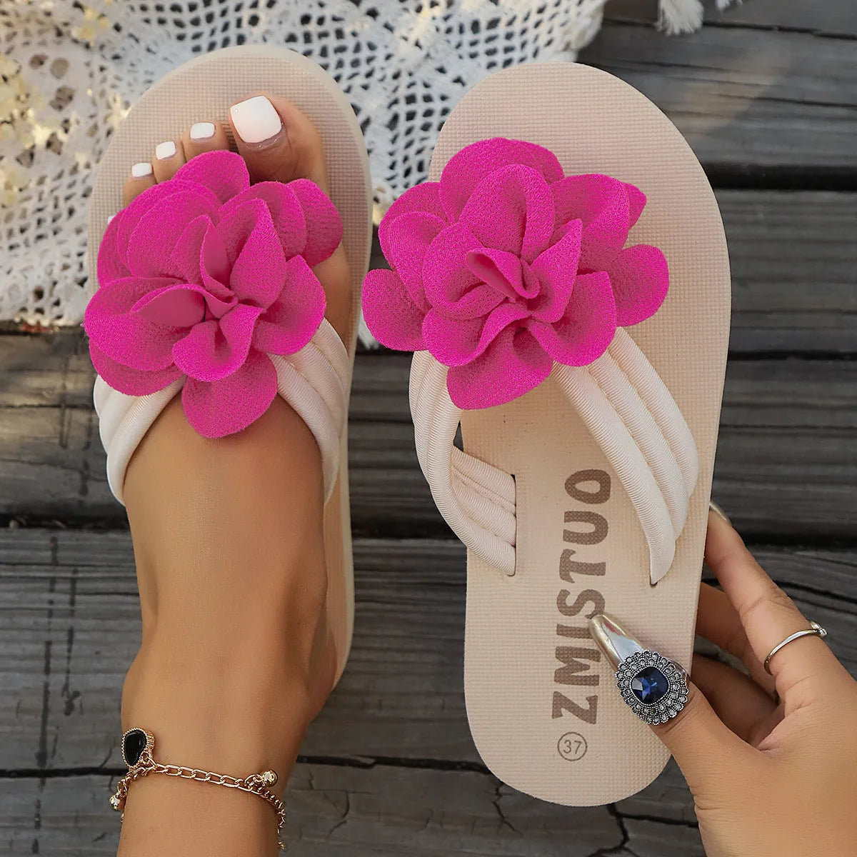 Plus size solid colour flip flop slippers with a flower detail on the upper, shown in beige.