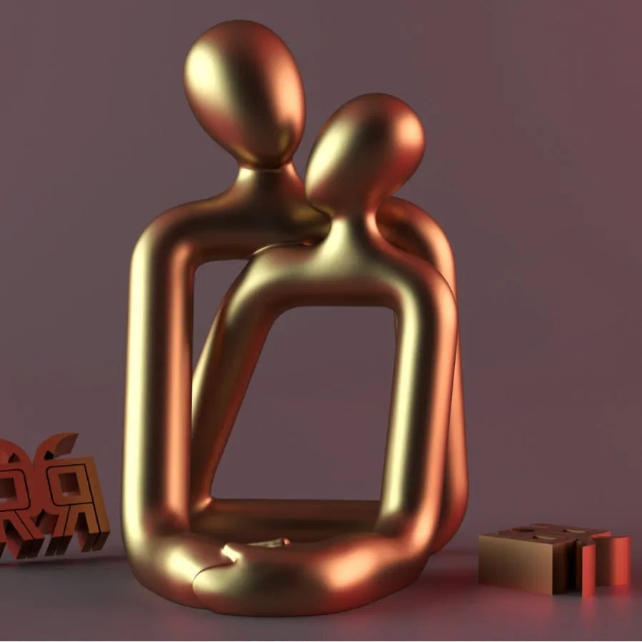 Modern loving couple resin statue in milky white or gold on a bookshelf.
