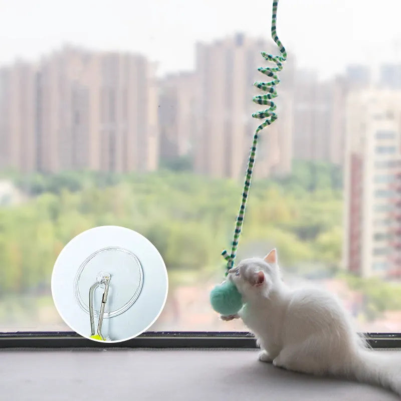 Spring cat toy with red inflatable ball hanging from suction cup next to bell stick accessory