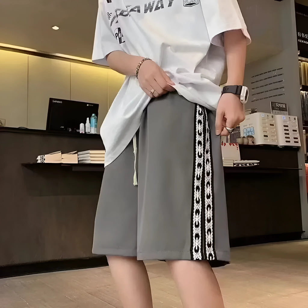 Men's black baggy track pants with loose fit design and elastic waistband for sports wear