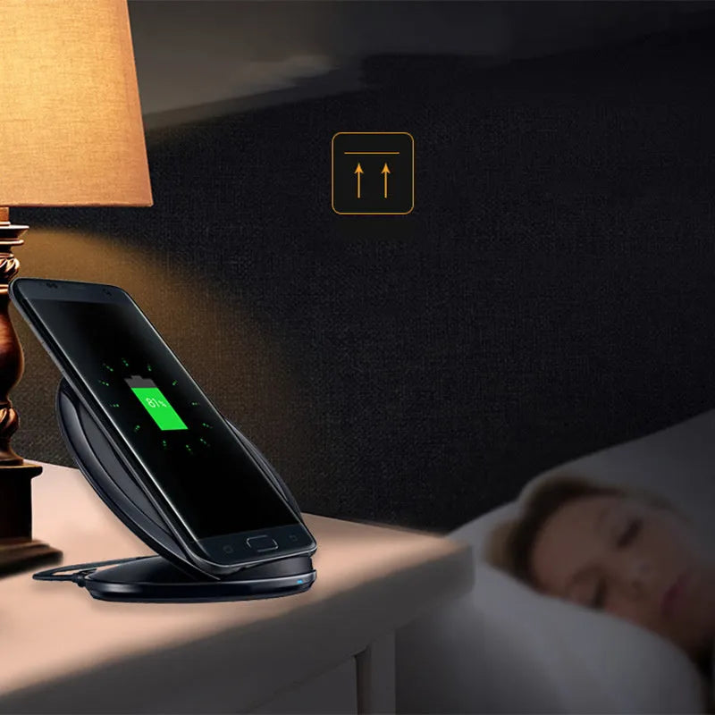 Black Qi wireless charging pad for Samsung Galaxy Note Edge on a wooden surface