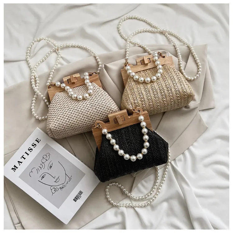 Women's woven straw shoulder bag with pearl chain strap and zippered interior pockets in beige, black, or khaki