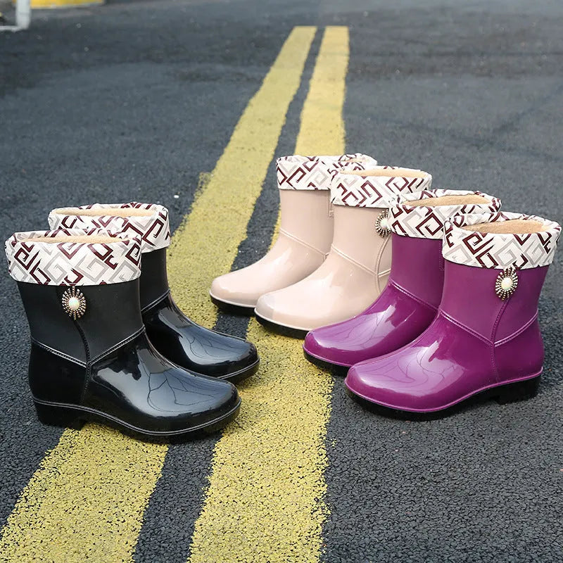 Women's purple PVC middle tube rain boots with a non-slip sole on a wet surface.