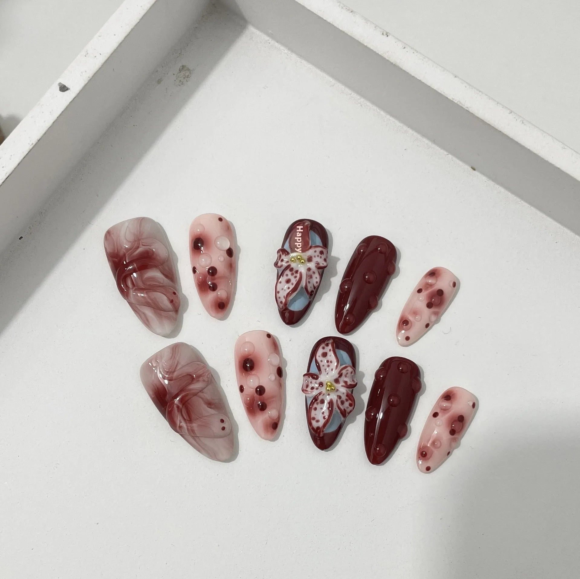 Set of almond-shaped false nails with hand-painted 3D rose and starry sky designs, showing ultra-thin edges.