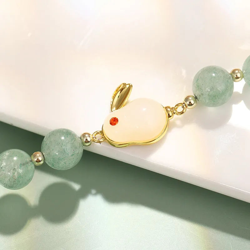 Rabbit charm bracelet with green aventurine stone on copper and gold chain.