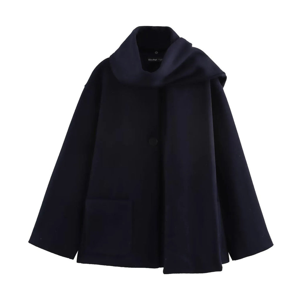Women's long black overcoat with grey artificial fur collar, showing longline silhouette and pocket detail.