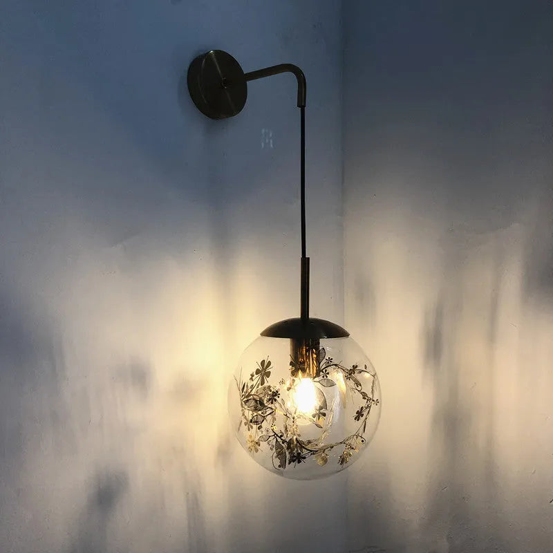 Modern glass wall lamp with golden flower pattern, 20cm size, emitting warm LED light.