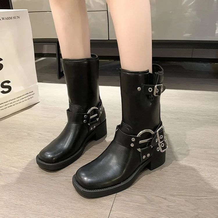 Women's black leather platform boots with a silver belt buckle, shown from the side.