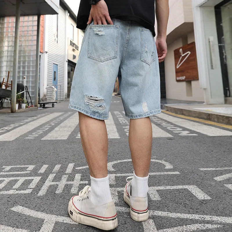 Light blue distressed denim shorts with ripped detailing and loose fit design