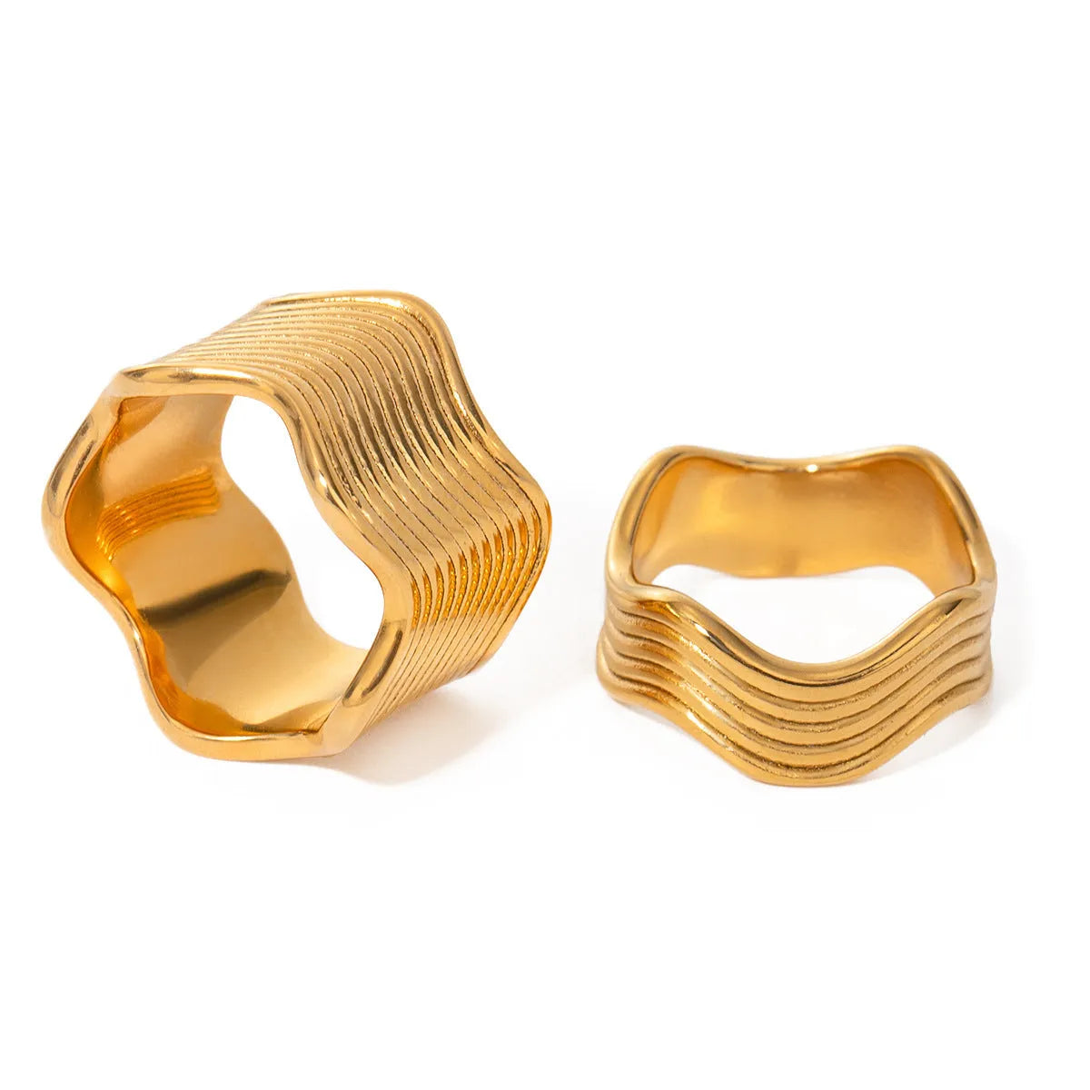 Close-up of a stainless steel ring with a wide geometric wave pattern on a white background.
