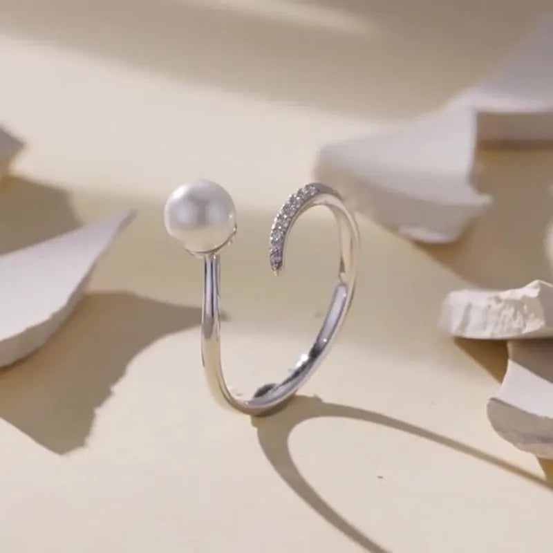 Adjustable sterling silver ring with natural shell pearls on open loop design